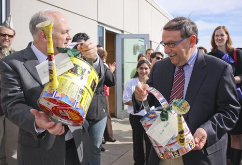 University President Steven Knapp, left, and Executive Vice President and Treasurer Lou Katz compare their watering cans made from recyclable materials Monday morning. Ashley-Lynn Goldstein/Hatchet Photographer