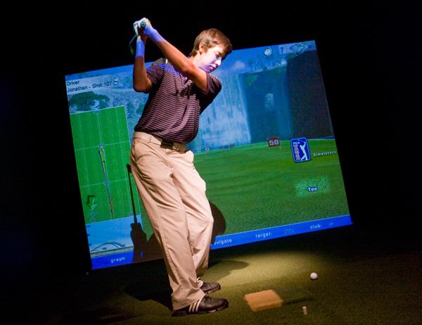 Freshman Jack Persons takes a swing in the Colonials practice facility in the Smith Center. The V1 Pro Video Analysis Software has been installed for golfers to analyze and compare their swings. Hatchet File Photo