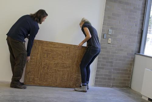 Master of fine arts student Travis Beauchene and his wife Britney move his artwork while preparing the gallery for the Caged In exhibit. Delaney Walsh | Photo Editor