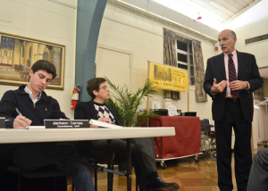 At a local politics meeting in March, Jackson Carnes, left, and Asher Corson, center, demand the University pay for altering the alley. Hatchet File Photo.