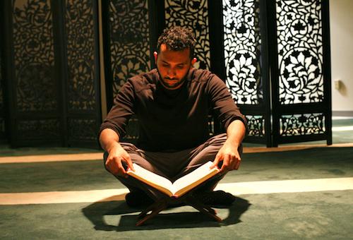 Muslim Student Association president Aabid Mohiuddin reads the Quran in a Marvin Center prayer room.