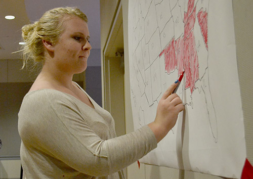 Sophomore Taylor Walters colors in a map of the United States at the College Republicans watch party as election results are announced. Aly Kruse | Hatchet Staff Photographer