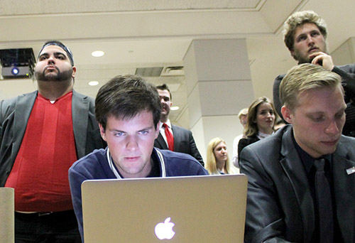Freshman Reed Westscott tracks election results on his laptop as other members of the College Republicans watch election announcements on TV. Jordan McDonald | Hatchet Photographer