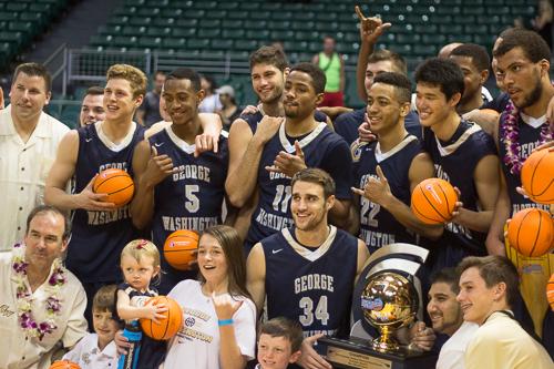 Members of the mens basketball team and coach Mike Lonergans family pose with the Diamond Head Classic championship trophy after defeating No. 11 Wichita State 60-54. Nora Princiotti | Hatchet Staff Photographer