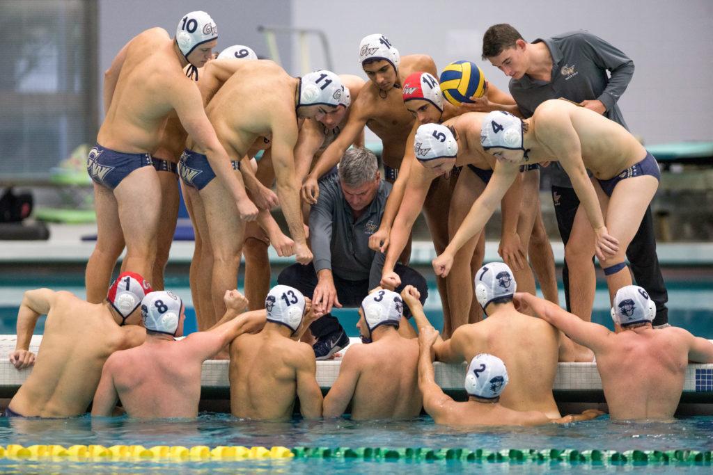 The men's water polo team huddles around first-year head coach Barry King during the team's season opener at Navy Saturday.