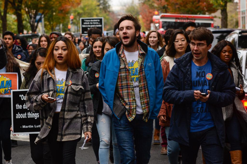 (Left to right) Students Keiko Tsuboi, Matt Zimmer and Henry Manning lead participants in the walkout down H Street toward the Farragut North Metro station, where they then traveled to the Capitol.