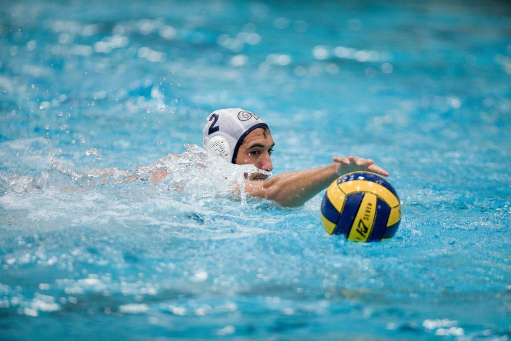 Sophomore+Atakan+Destici+swims+with+the+ball+during+a+mens+water+polo+game+at+Navy+in+September.