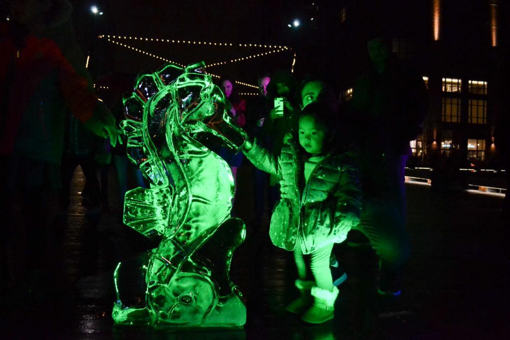 Ivanna Perez and her father, Joseph, check out a seahorse ice sculpture at the Fire & Ice Festival at The Wharf Saturday.