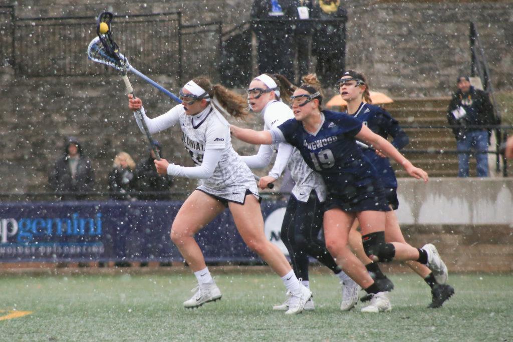 Freshman attacker Cescily-Jo Wheeler craddles the ball away from opposing defenders during a lacrosse game against Longwood Saturday.