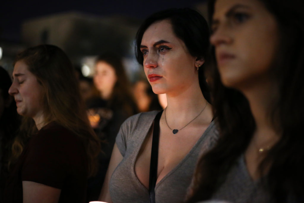 Freshman Jillian Kislow breaks down in tears at a vigil to remember the victims of last weeks shooting in Parkland, Fla. held in Kogan Plaza Wednesday night.