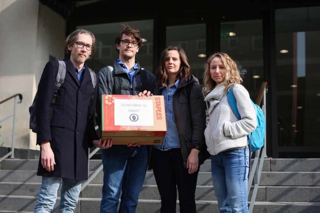 (From left) Graduate students Michael Horka, Matt Payne, Jackie Bolduan and Julie Chamberlain brought more than 100 letters to officials in Rice Hall Thursday morning demanding a meeting on graduate student unionization.
