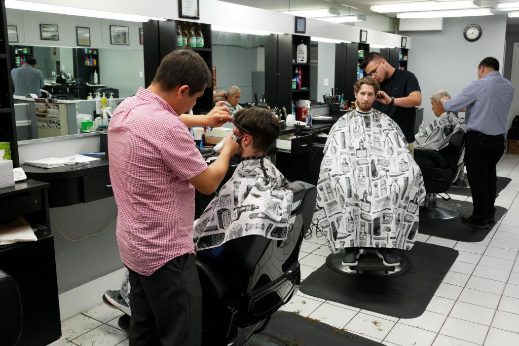 Barbers trim clients hair at the Watergate Barber, located at 2536 Virginia Ave. NW.