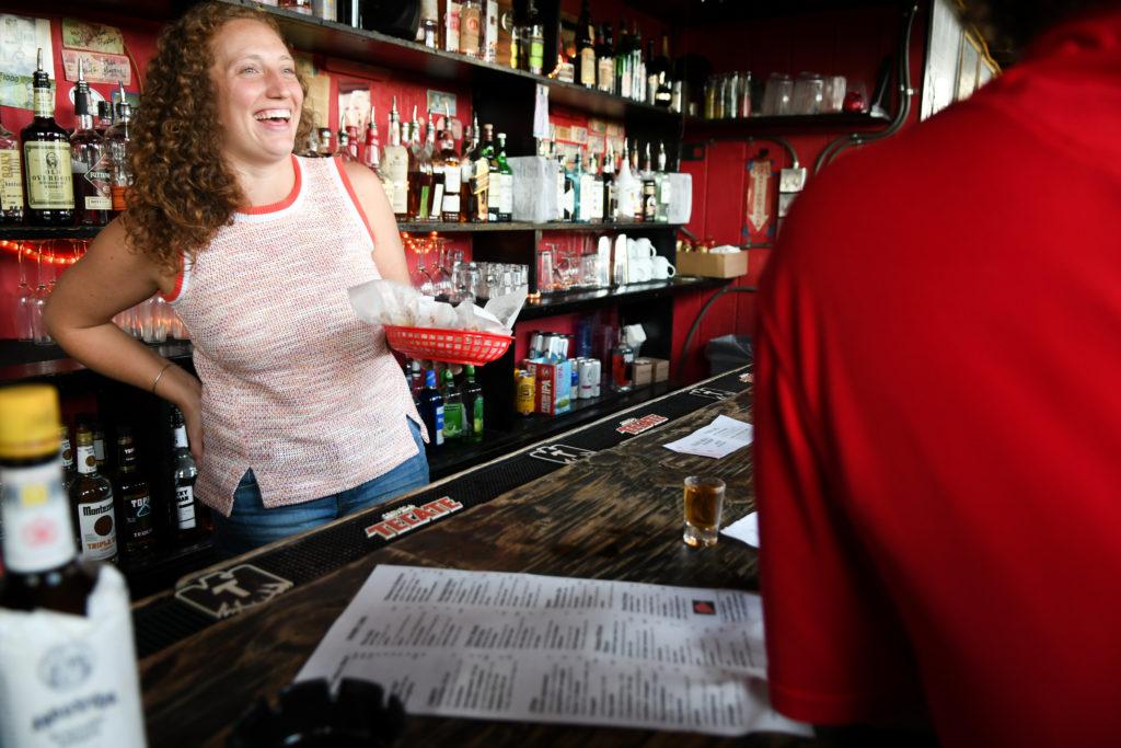 Rachel Stone, a bartender at Red Derby at 3718 14th St. NW, serves food to a customer.