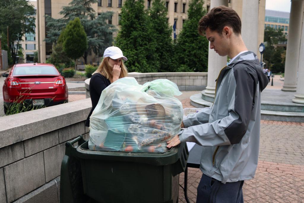 Sophomore Jonathan Kvilhaug and junior Katherine Tucker bag compost material in Kogan Plaza. 