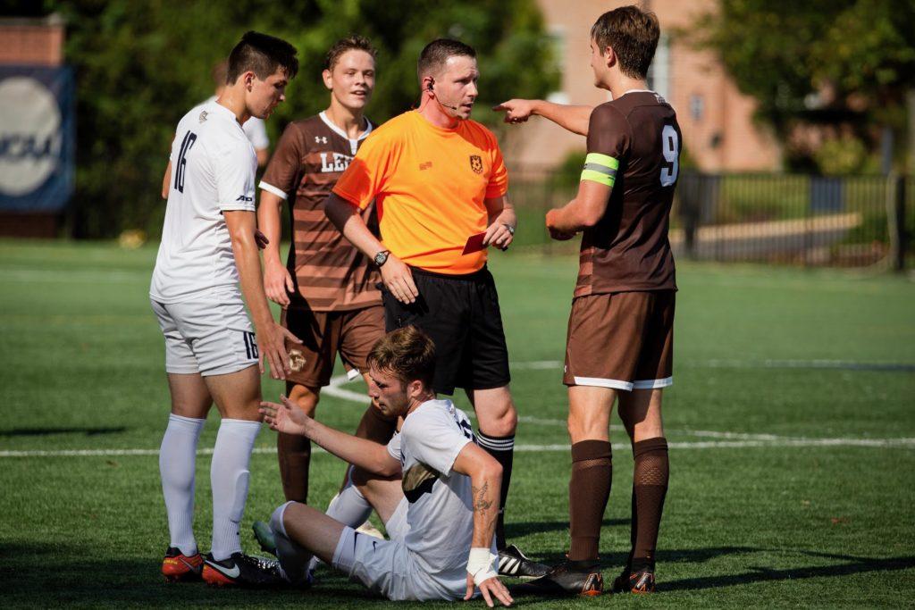 Men’s soccer players gather around a referee in a physical game against Lehigh Saturday.