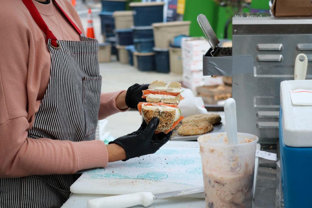 An employee prepares bagel sandwiches at Call Your Mother's stand at the Dupont Circle Farmers Market.