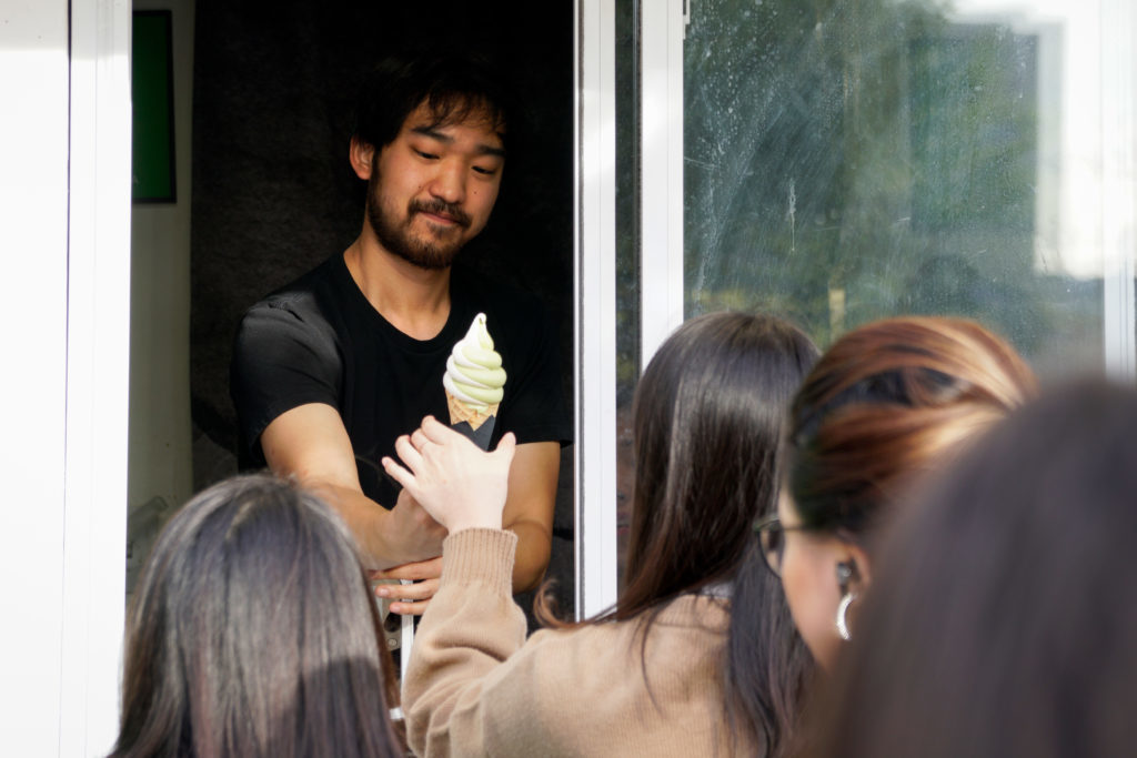 An employee hands a cone of matcha ice cream to a customer at Bon Matcha, located on the corner of I and 20th streets NW. 