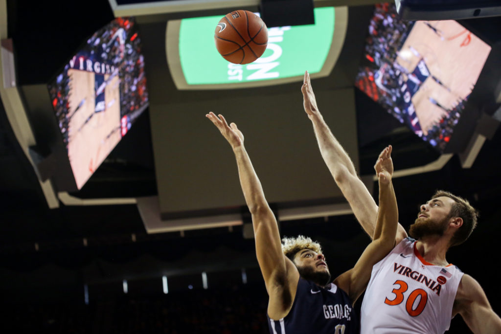 Sophomore guard Justin Mazzulla jumps for a ball along with a Virginia forward during a mens basketball game last week.  
