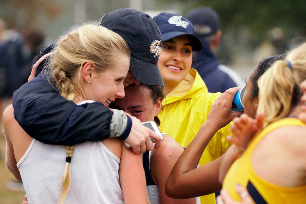The womens cross country team embraces after the Atlantic 10 Championship last month. 