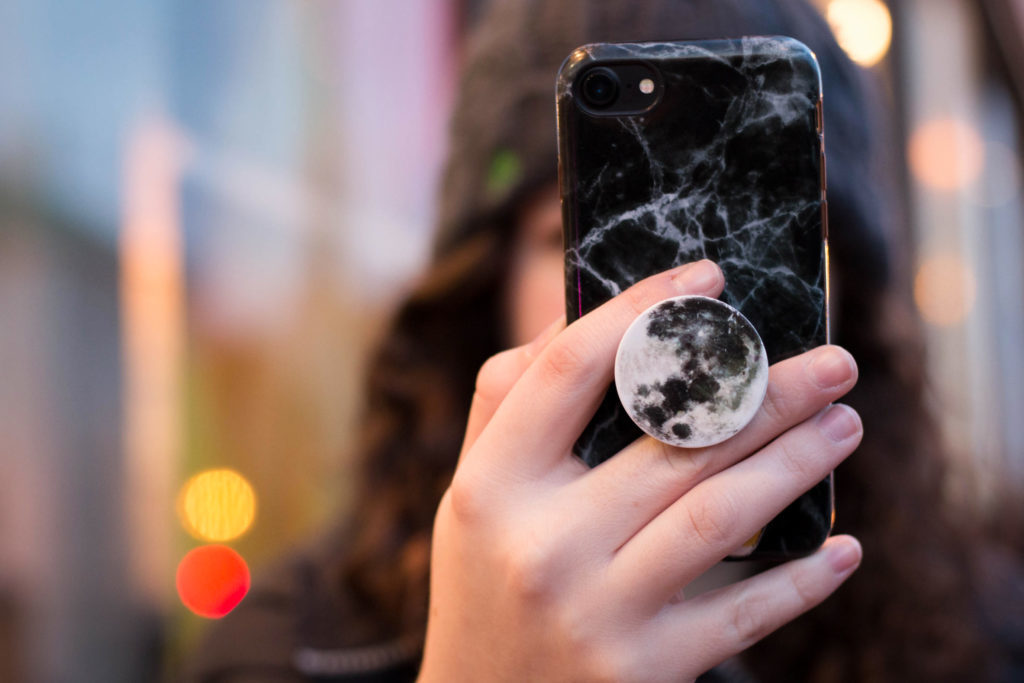 PopSockets+%28%2410+to+%2415%29+go+on+the+back+of+cellphones+in+a+circular+shape+in+a+variety+of+solid%2C+sparkly+and+trendy+marbled+designs.+