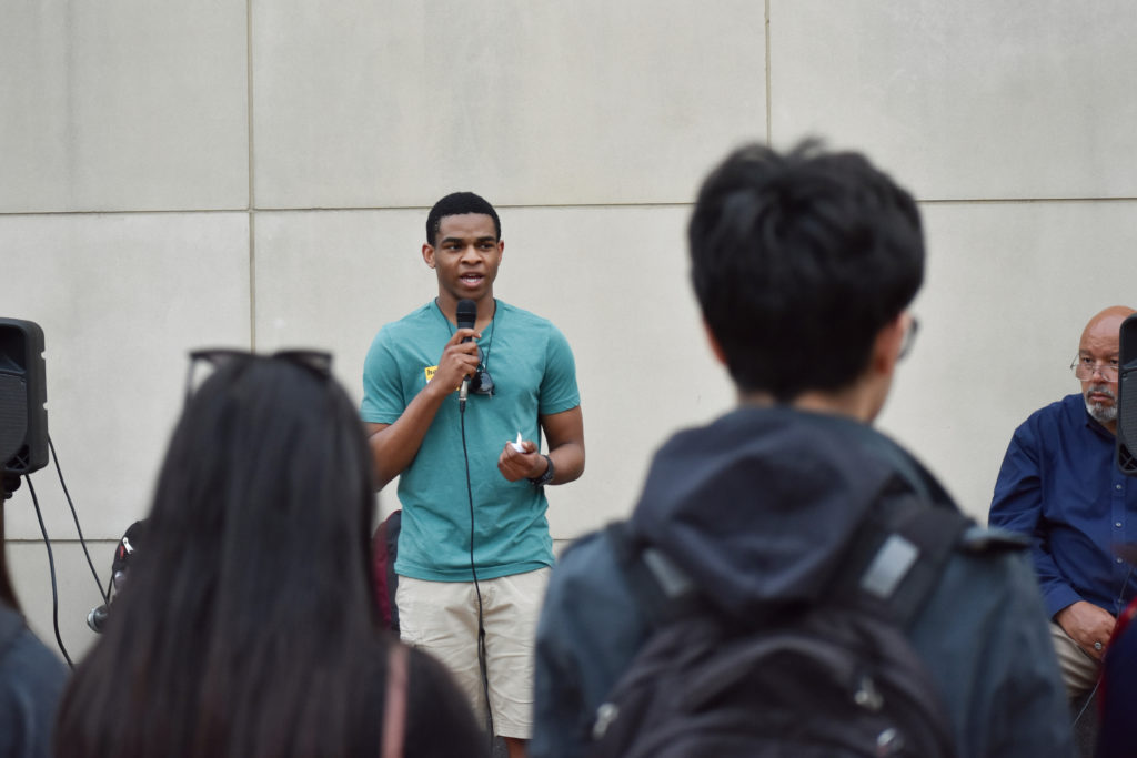 Junior Dan Ohiri speaks to students in Kogan Plaza on Wednesday during a commemoration for victims of a bombing in Sri Lanka on Easter.