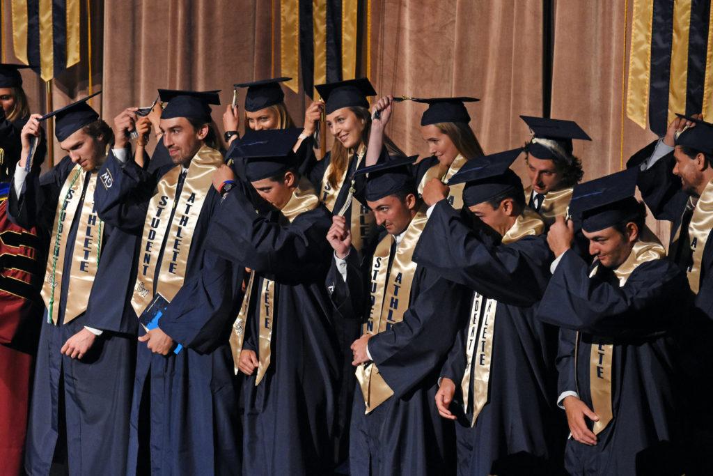 Student-athletes switch their tassels after receiving diplomas at the athletics commencement. 