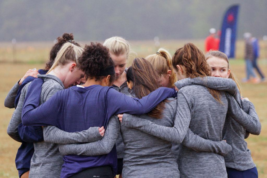 The womens cross country team huddles before a meet last October. The team rostered 17 runners last season compared to 13 this year. 