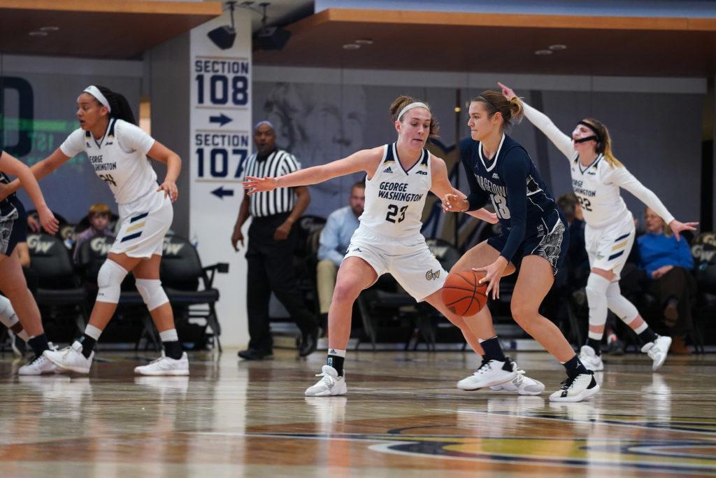 Freshman forward Faith Blethen blocks a Georgetown player in the game Sunday. The Colonials beat the Hoyas 52–49. 