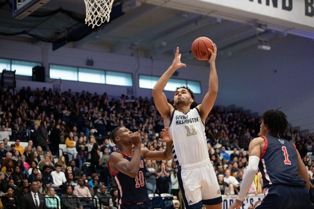 Senior forward Arnaldo Toro takes the ball to the rim during Saturday's game against the Bison. The Colonials beat Howard 76–62 to earn their first win of the season.