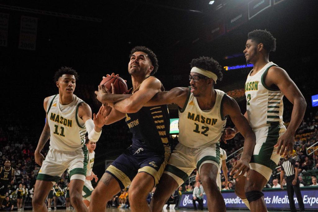 Senior forward Arnaldo Toro fights through traffic in last week's game against George Mason. In the Colonials' game against Duquesne, Toro grabbed a floor-leading 14 rebounds and sunk 16 points on 7-of-12 shooting.