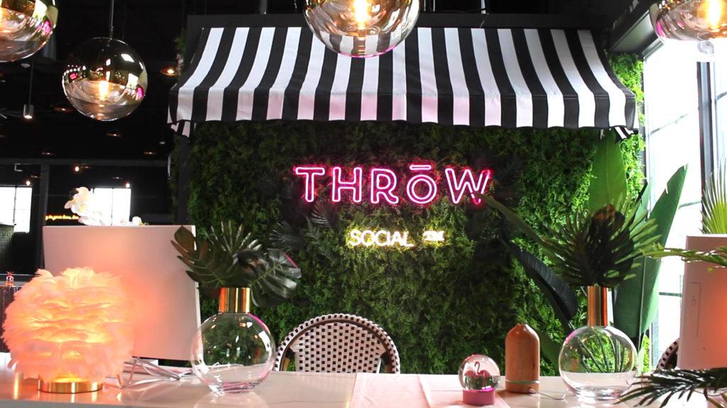 Guests can enjoy tropical drinks at the bar and throw footballs on the top floor of THRōW Social/Kick Axe Throwing, which will open Friday.