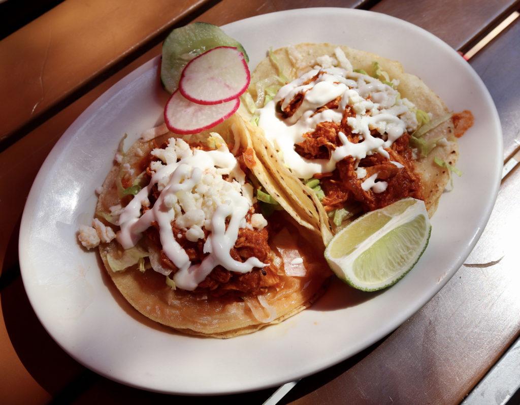 The tomatoes and chipotle in adobo in the marinade of El Sol's chicken tinga tacos give them a bright red color.