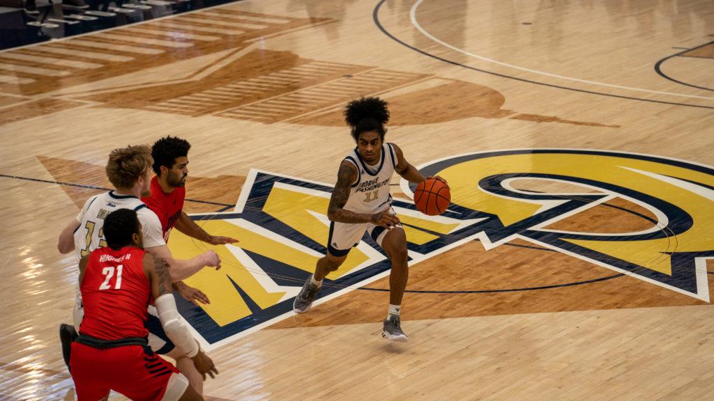 Sophomore guard James Bishop dribbles up the court during a game against Duquesne Sunday. GW split its weekend series with the Dukes, winning Sunday's game.