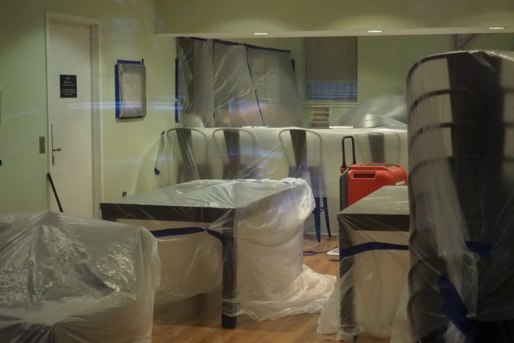 Sheets of plastic covered furniture and appliances in Kappa Delta and Alpha Phi’s townhouses alongside equipment from Belfor Property Restoration, which conducts mold removal and remediation services. 