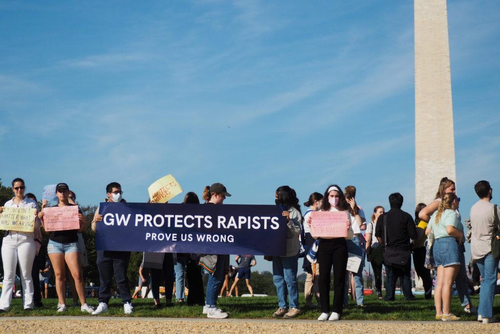 Students silently protested with their signs behind Commencement, facing the setup on the National Mall. 