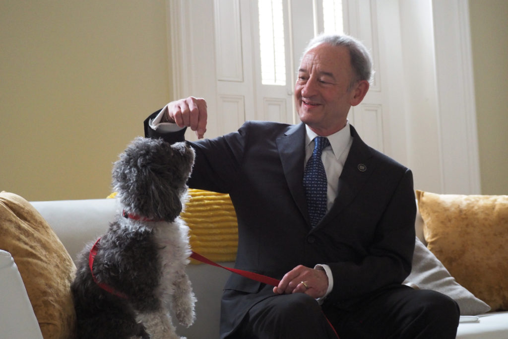 Interim University President Mark Wrighton feeds a treat to his dog Spike at the F Street House. Wrighton and his furry friend have become familiar faces to the streets of Foggy Bottom since January.