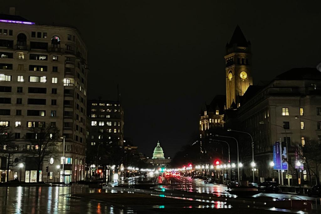 Rain puddles reflect the city lights to create an illuminated path toward the U.S. Capitol building under the cover of nightfall in D.C. 