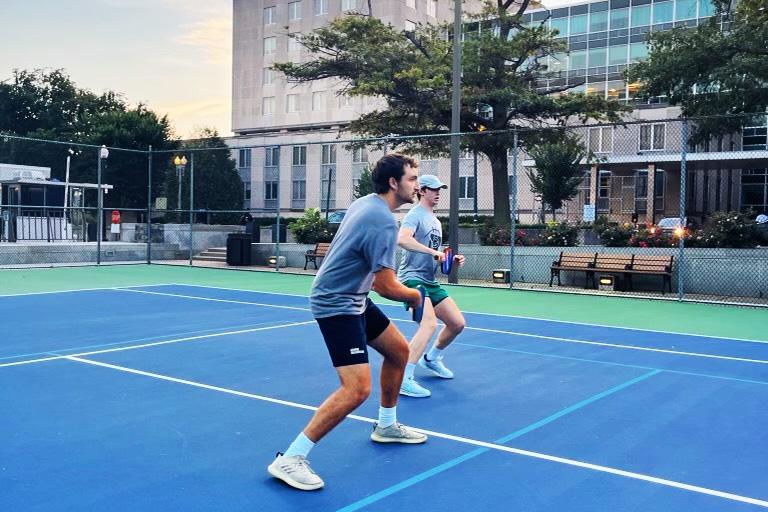 Dill With It’s players describe the sport as a relaxing way to exercise free of stress. Every evening, the group meets at the local court, suited up in athletic tees, shorts and sneakers to strike a neon yellow “pickleball” back and forth across a low net.