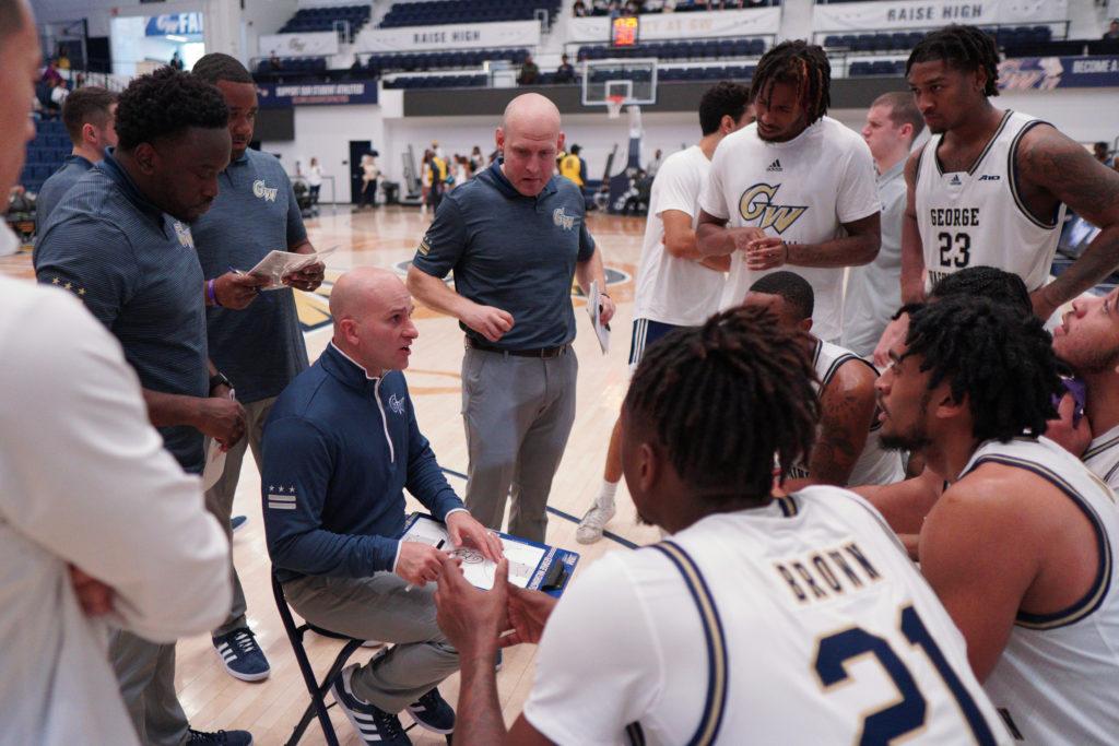The+men%E2%80%99s+basketball+squad+huddles+around+Head+Coach+Chris+Caputo%2C+the+program%E2%80%99s+new+leader+who+has+sought+to+restore+a+culture+of+winning+in+the+Smith+Center.