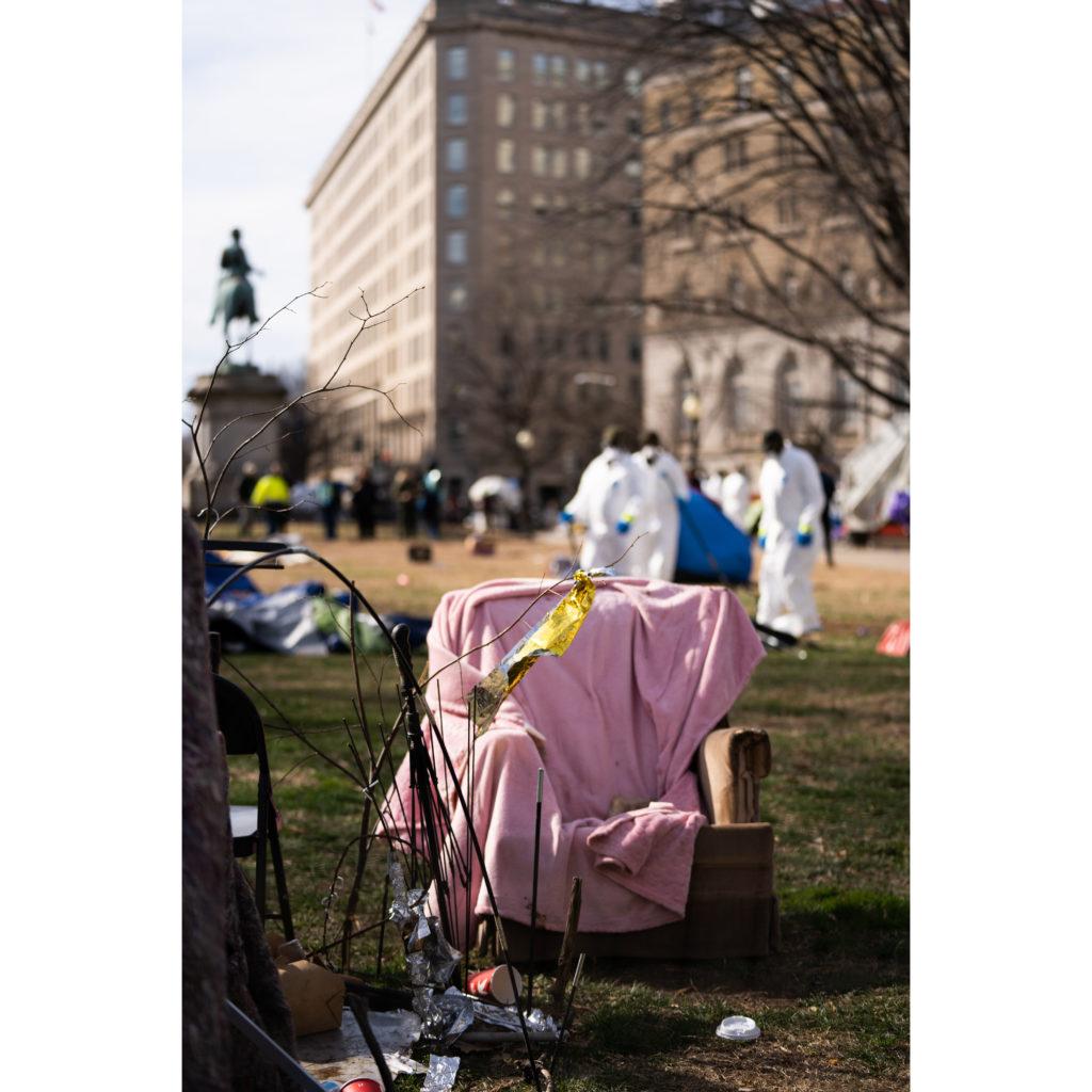 An abandoned chair sits in McPherson Park Wednesday morning as NPS workers in hazmat suits work to clear out the encampment, formerly home to 56 people.