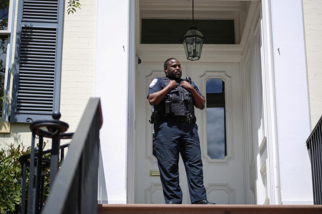 A GWPD officer stands infront of the presidents house on F Street during a protest against arming GWPD in April.
