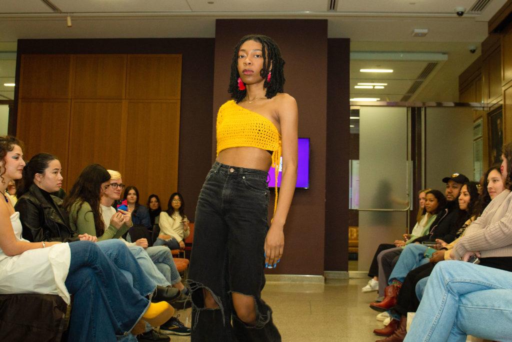 A student model sports a vibrant crocheted top and baggy dark-washed jeans during the spring-themed fashion show at the GWU Textile Museum Friday. 