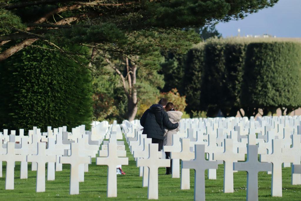 Senior Blake Hindle and sophomore Grace Brenner stand in front of a grave at the American Cemetery in Normandy.