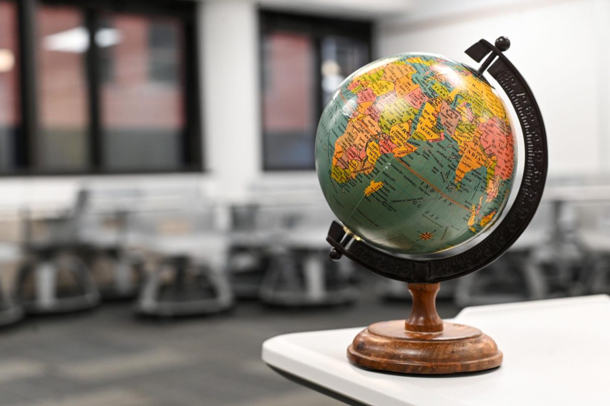 A globe rests on a classroom desk. 