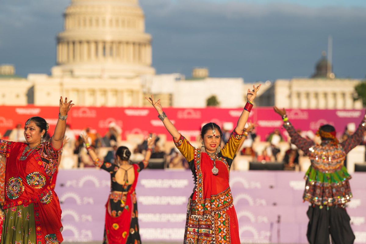 A group of dancers stand with arms outstretched during a World Culture Festival performance on the National Mall this weekend.