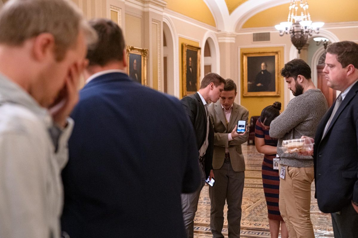 After a long day on Capitol Hill, members of the press listen to the Senate live feed outside the Senate Chamber as they wait for the last ten Senators to vote to pass the bill to keep the government open.