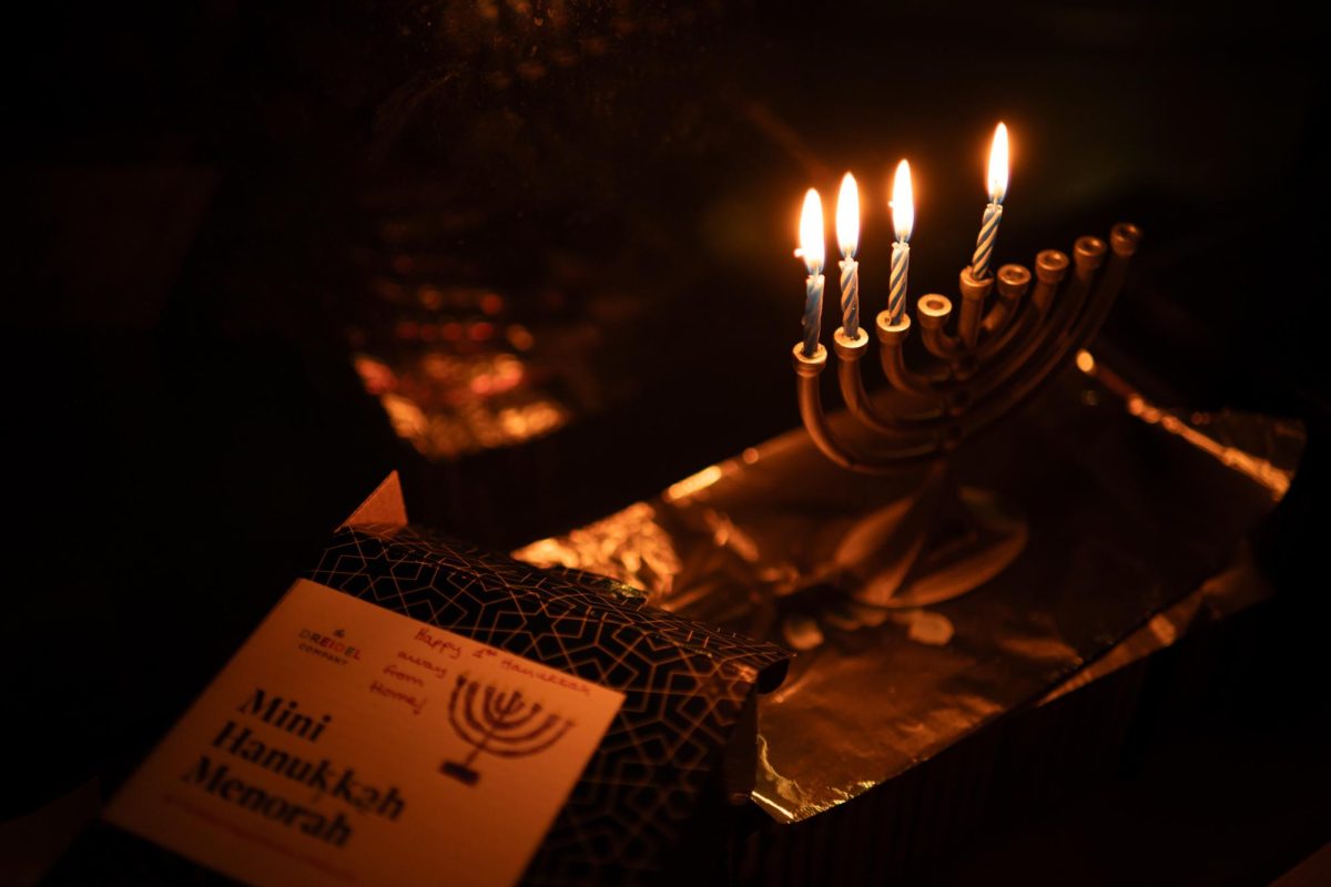 A lit menorah illuminates a note from loves ones wishing a Happy Hanukkah.