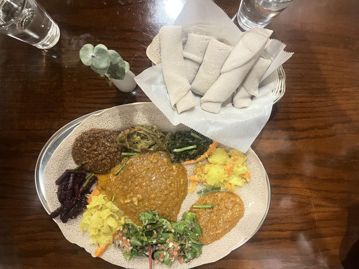 Tsehays vegan combination plate, complete with stews and red lentils, fresh-cut collard greens, cabbage, string beans and beets overtop a rolled-out injera.