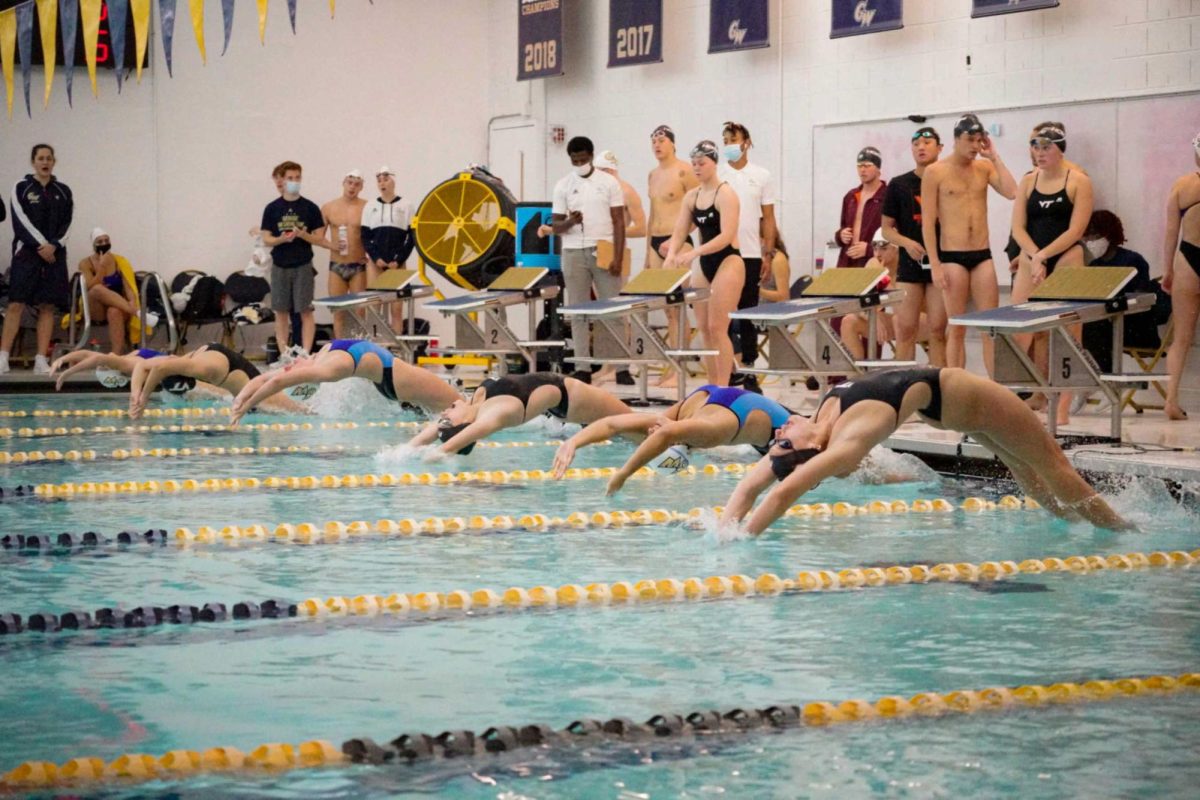 Swimmers dive backward into the pool at the start of a race. 