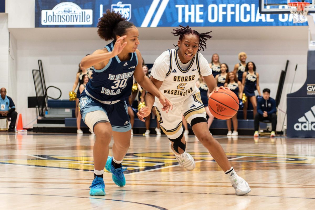 Sophomore guard Nya Robertson bounds past her opponent in a match against URI.